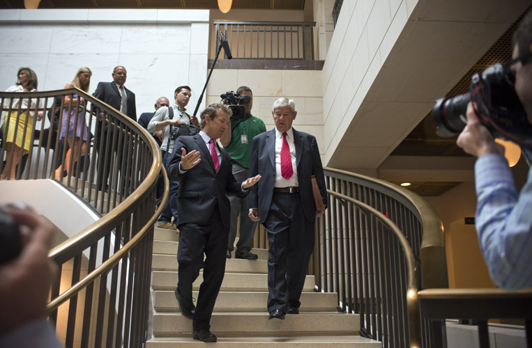 A heavy media presence follows Rand Paul as he speaks with former Florida Democratic senator Bob Graham. Both men were on their way to a press conference where Paul would co-introduce legislation that called on the White House to release the remaining classified and redacted 28-pages of the 9/11 Commission Report that many believe reveals the role Saudi Arabia played in financing the terrorist attacks.